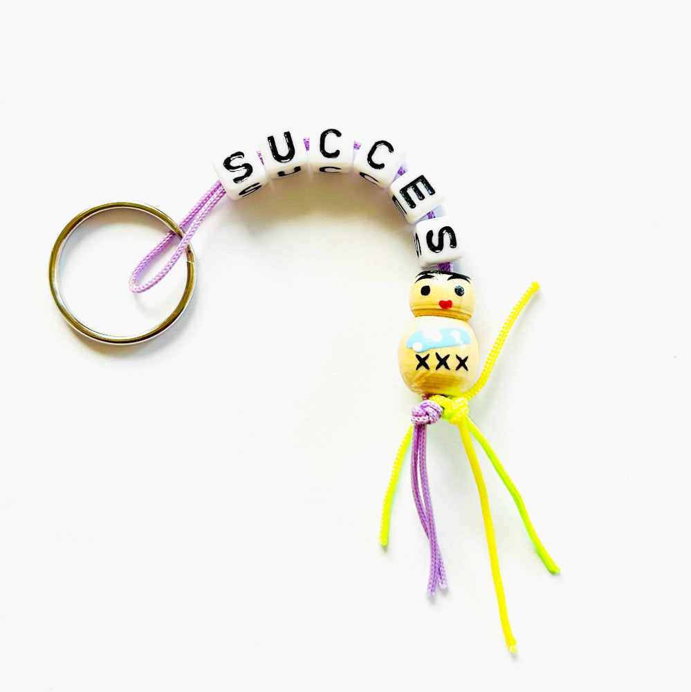 Key chain success with wooden good luck doll